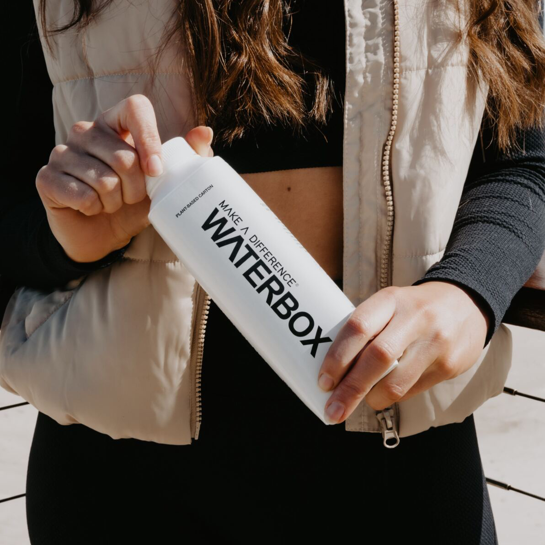 Person Holding Waterbox Carton Against Their Waist